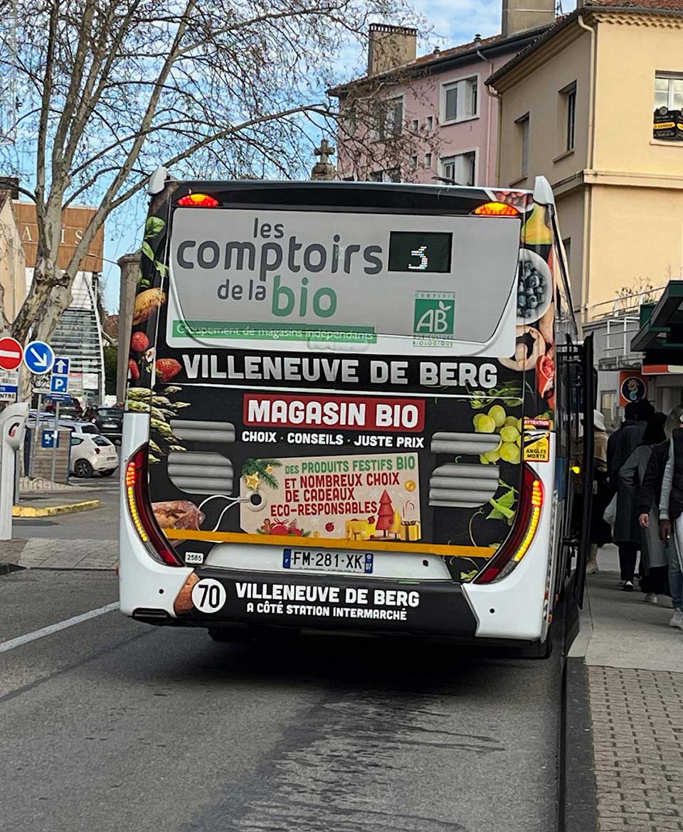 Image publicité longue conservation : Photo covering arrière de bus, cul de bus - Les comptoirs de la bio - Aubenas (07) réseau de transport Tout'EnBus - Rue Media